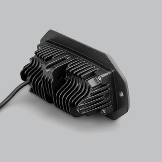 Rear of the CX4 flush mount light, showing the deep finned heatsink behind the mounting flange, the retaining screws and the cable leaving the back