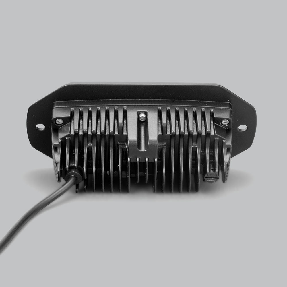 The CX4 flush mount seen square on from behind, the finned heatsink centred in the flange with a fixing hole at each end and the lead running out to one side