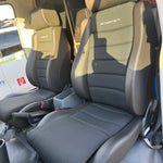 Car interior with folded seat showing brand logo
