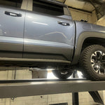 Gray SUV on a lift in a garage