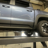 Gray SUV on a lift in a garage