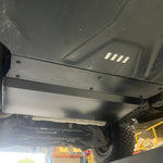 Close-up of a vehicle's undercarriage with a metal guard