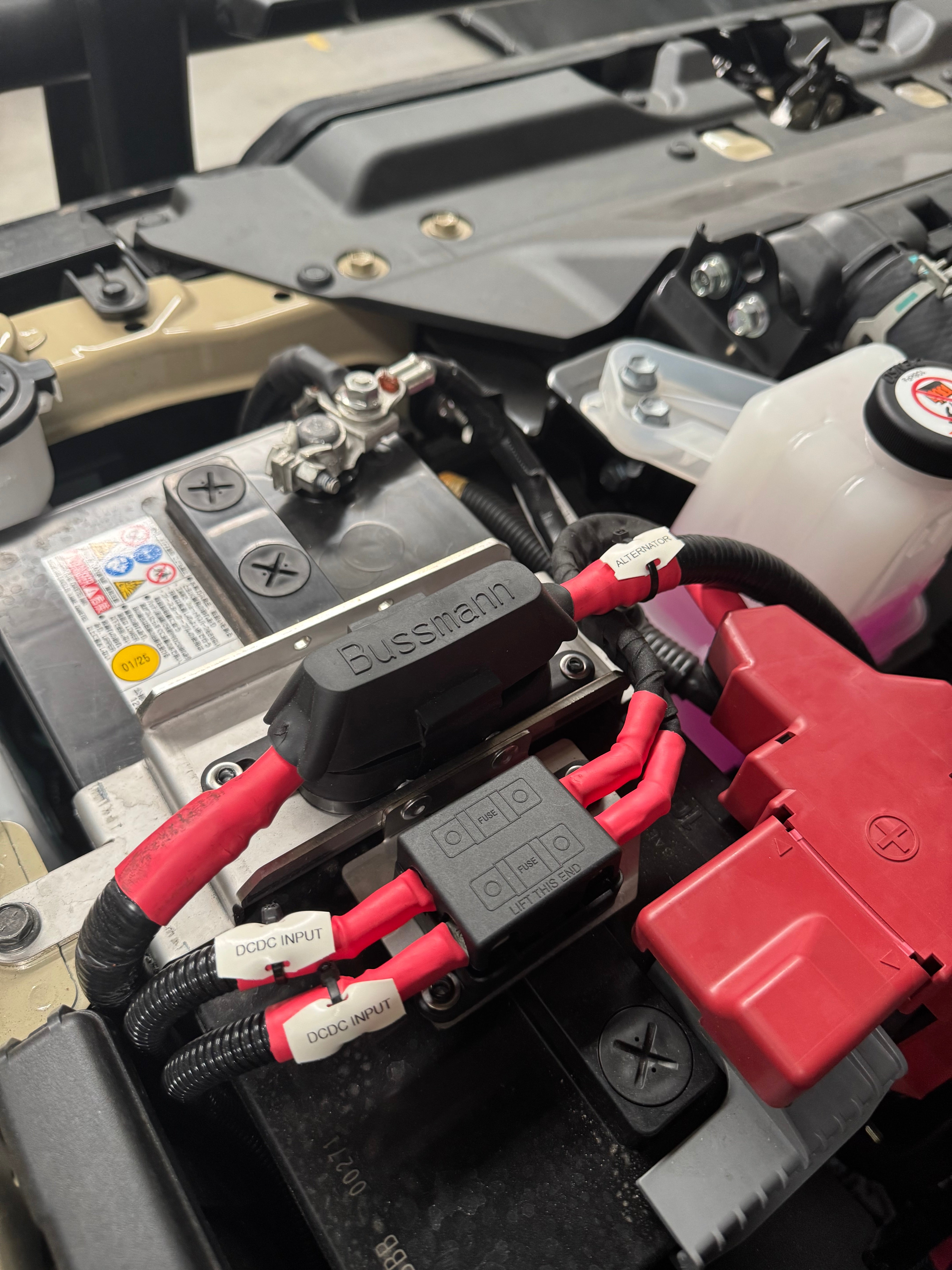 Close-up of a battery connection with red and black cables on a mechanical component.