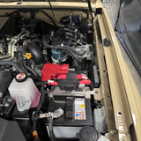 Open car hood revealing engine and battery components.