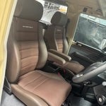 Interior of a vehicle with brown seats and visible branding.