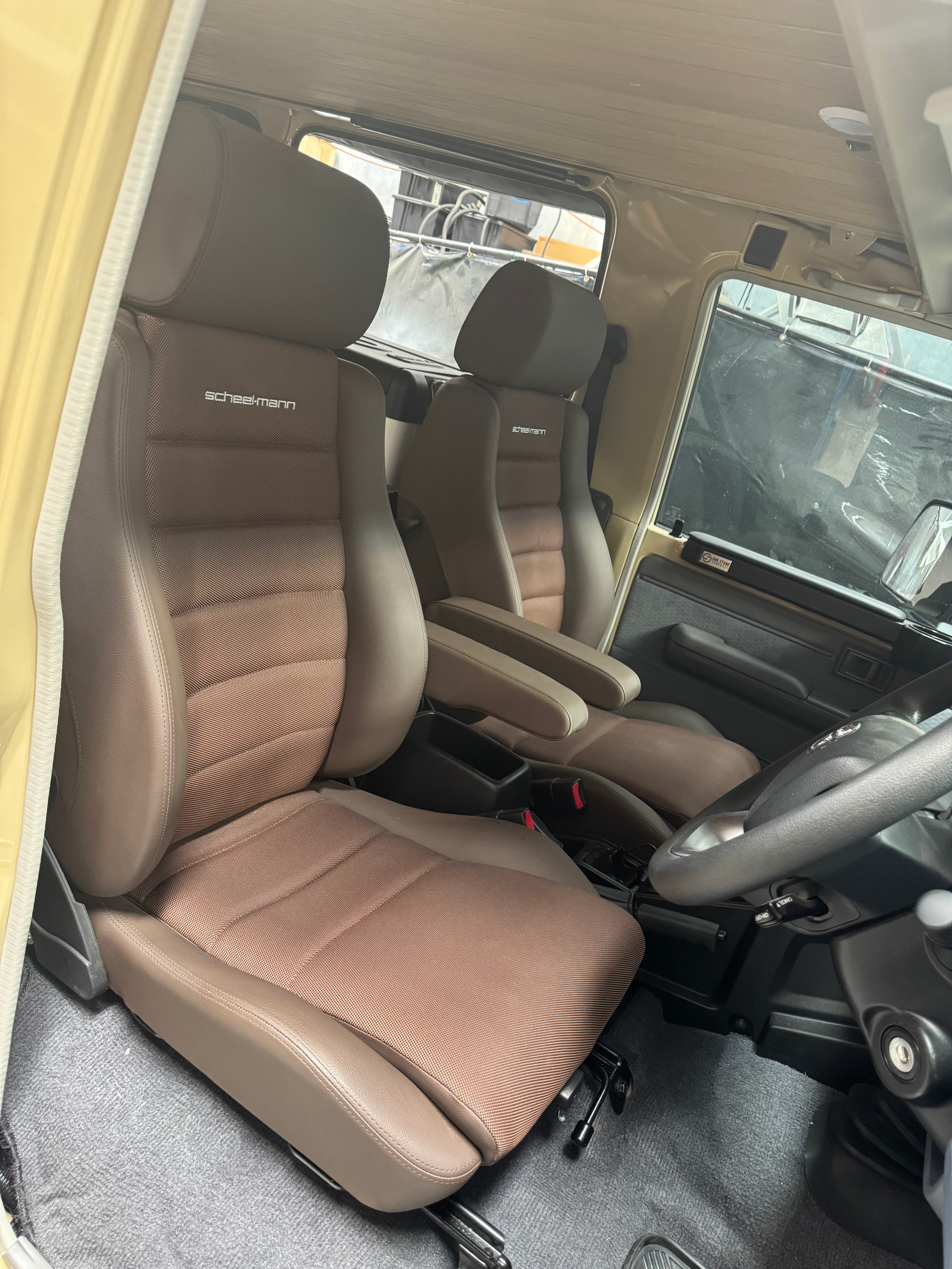 Interior of a vehicle with brown seats and visible branding.