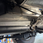 Close-up of a vehicle's undercarriage with suspension components & water tank.