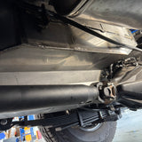 Close-up of a vehicle's undercarriage with suspension components & water tank.