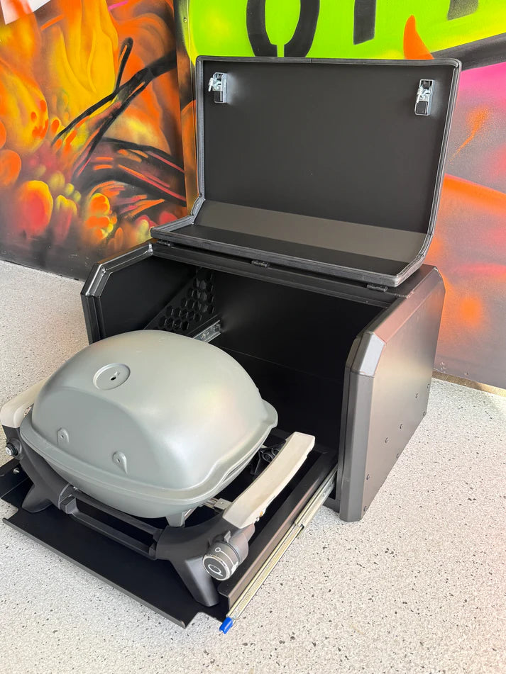 Black barbecue grill with a lid open, showing a portable barbecue inside, against a colorful abstract background.