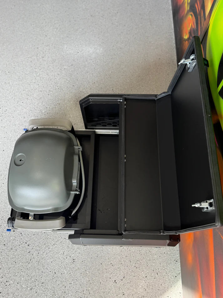 Gray and black grill on a white surface with a colorful object partially visible