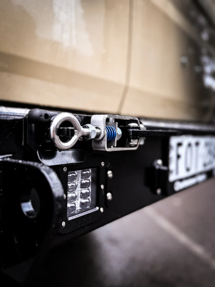 Close-up of a vehicle's license plate and light system with a blurred background.