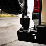 Close-up of a tow bar attached to a vehicle's hitch receiver.