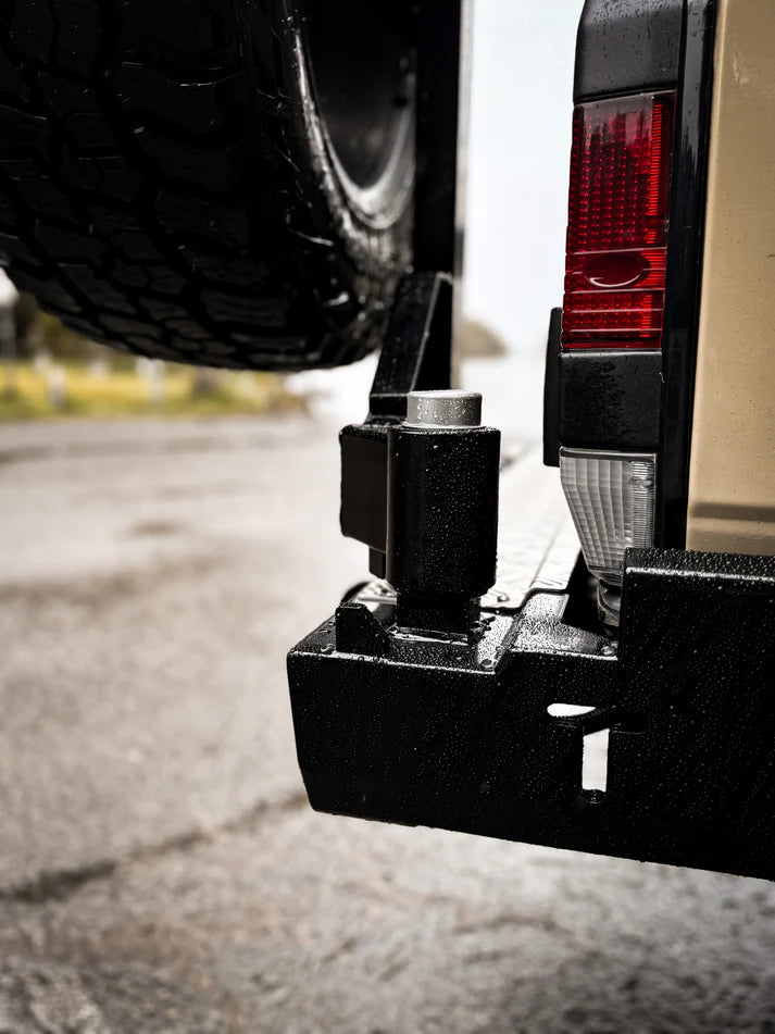 Close-up of a tow bar attached to a vehicle's hitch receiver.