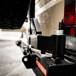 Close-up of a vehicle's hitch and trailer attachment on a road.
