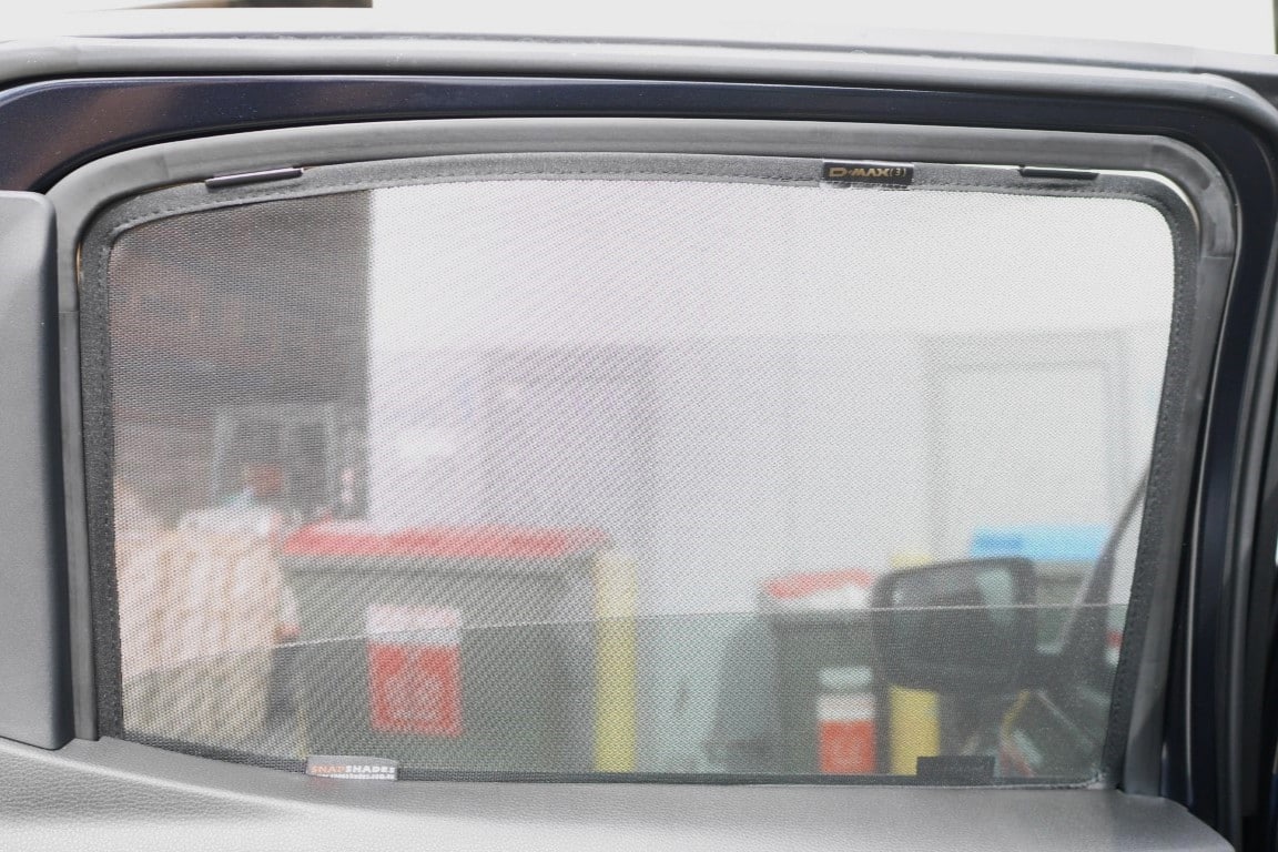 Car window with a sunshade in front of a gas station