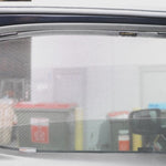 Car window with a sunshade in front of a gas station