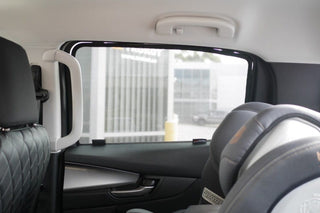 Car interior with a side window open, showing a blurred outdoor scene.