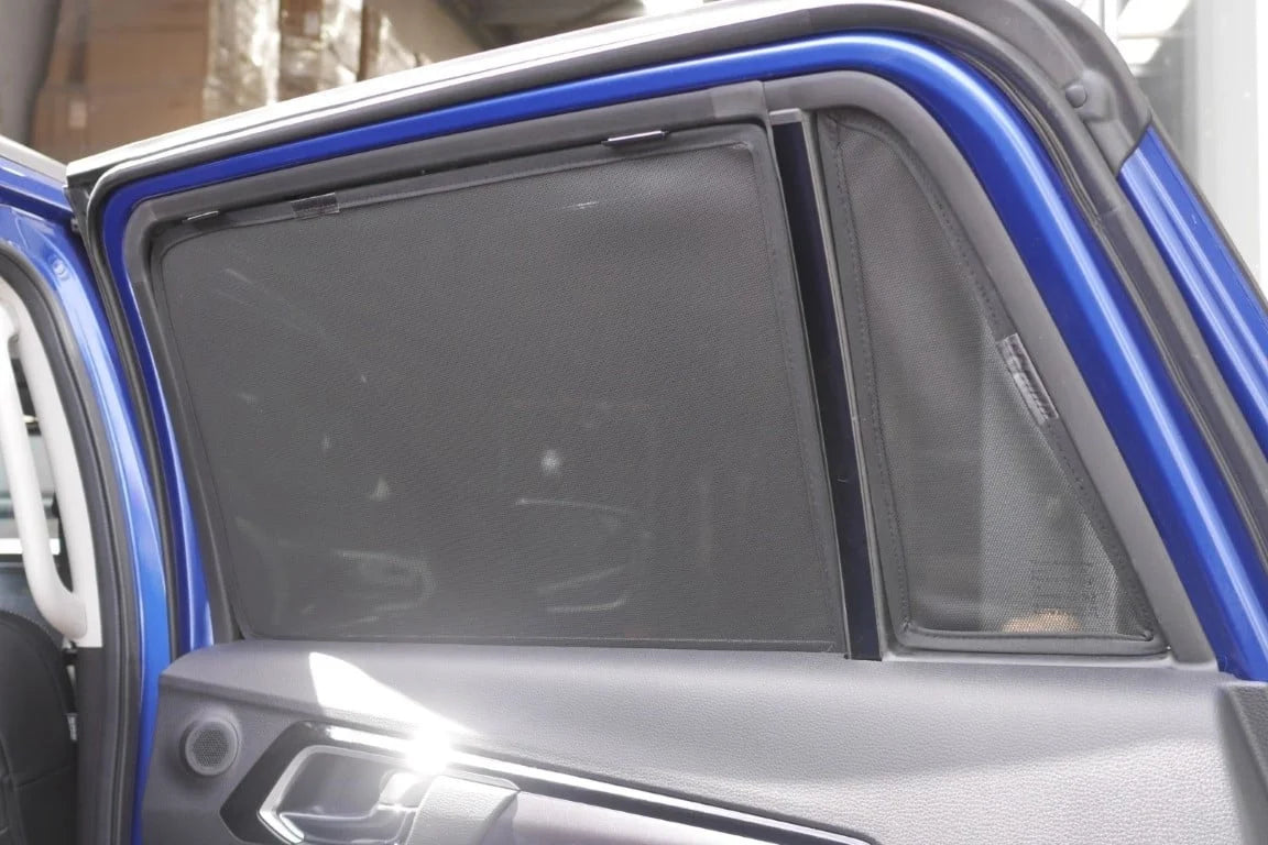 Car window with a sunshade pulled down, showing a blurred interior background.