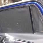 Car window with a sunshade pulled down, showing a blurred interior background.