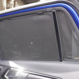 Car window with a sunshade pulled down, showing a blurred interior background.