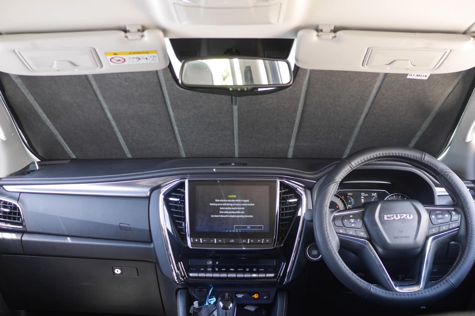 Car interior with dashboard, steering wheel, and infotainment system.