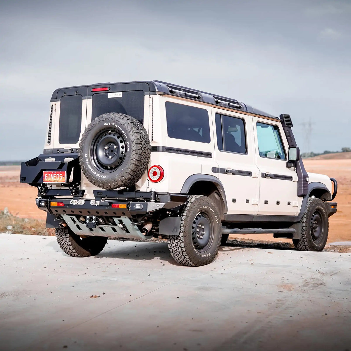 White off-road vehicle with a spare tire on a desert landscape