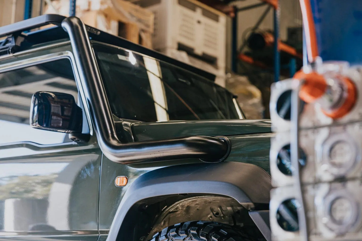 Close-up of a vehicle's side mirror and door handle with a blurred background