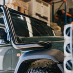 Close-up of a vehicle's side mirror and door handle with a blurred background