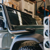 Close-up of a vehicle's side mirror and door handle with a blurred background