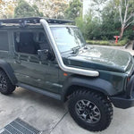 Green SUV with roof rack parked on a concrete surface