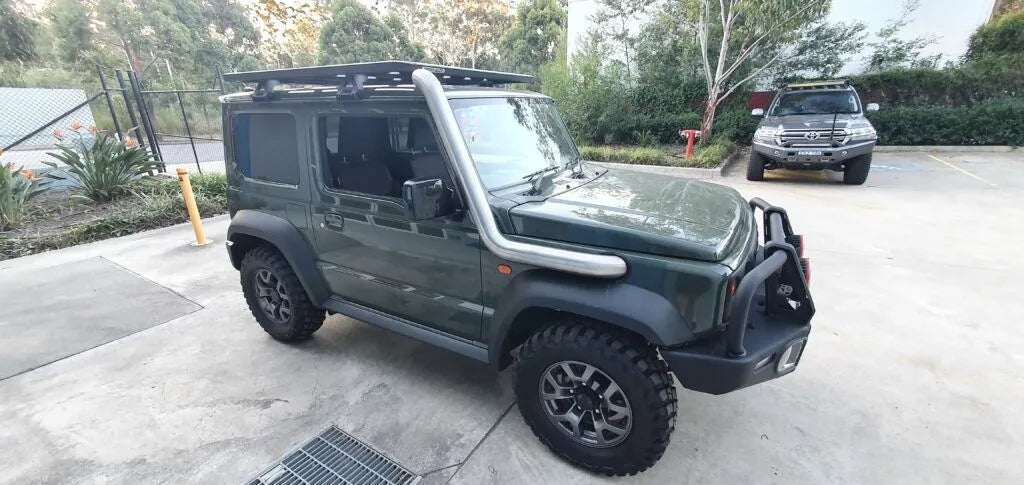 Green SUV with roof rack parked on a concrete surface