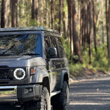SUV driving on a road surrounded by trees