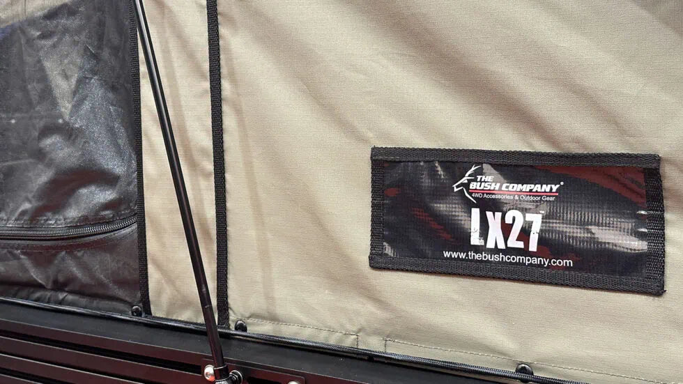 Close-up of a label on a tent with 'The Bush Company' branding and 'LX27' model number.
