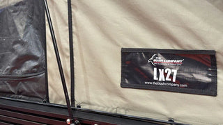 Close-up of a label on a tent with 'The Bush Company' branding and 'LX27' model number.