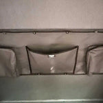 Gray storage compartment with multiple pockets on a vehicle interior.