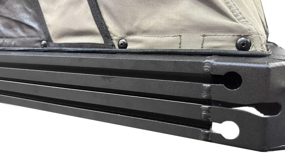 Close-up of a black metal bar with a beige fabric background
