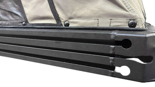Close-up of a black metal bar with a beige fabric background