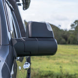 Side view of a vehicle's mirror with a blurred natural background
