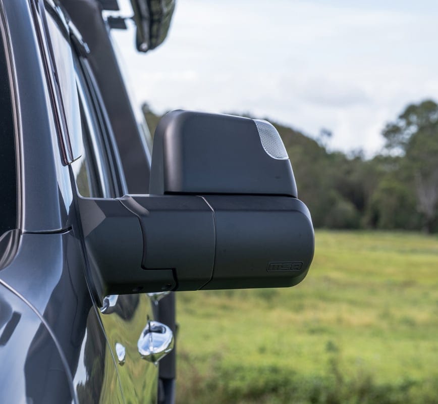 Side view of a vehicle's mirror with a blurred natural background