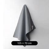 Gray towel hanging on a white wall with dimensions 125 x 70 cm displayed below.