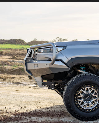 Toyota Hilux N90 front bar fitted, front three-quarter view on a dirt track