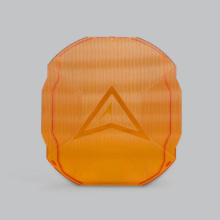 Amber ALTIQ Rogue panoramic lens cover, translucent orange with fine vertical ribbing and the raised Rogue chevron moulded into the centre