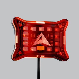 Red rock light cover lit from behind, the LEDs glowing through the panel with the resistor markings on the board visible and the ALTIQ arrow in the middle