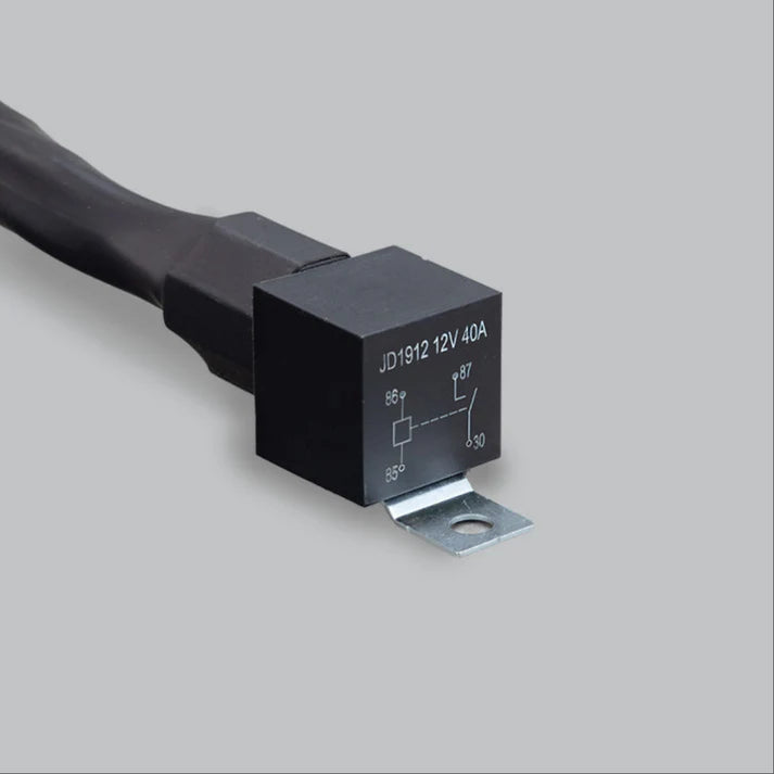 Close-up of the harness relay, a black cube printed JD1912 12V 40A with the coil and contact diagram and terminals 85, 86, 87 and 30 marked, on a zinc-plated mounting bracket