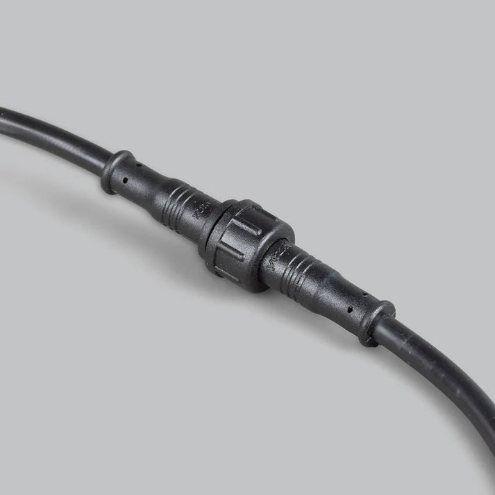 Two sealed two-pin connectors of the rock light harness screwed together, the knurled locking collar joining the male and female halves with strain-relief mouldings at each end