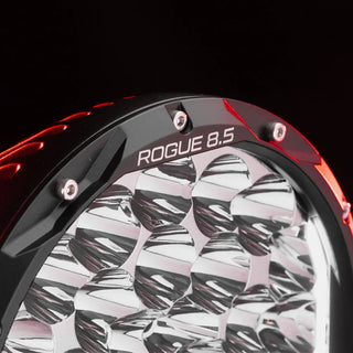 Close-up of the Rogue 8.5 bezel lit in red, the model name ROGUE 8.5 machined into the ring above the chrome reflector cups