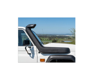 Safari snorkel fitted to a white LandCruiser 70 Series, running up the passenger side of the windscreen to a raised air ram, photographed against farmland and a clear sky