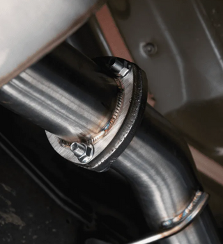 Close-up of a metal exhaust pipe with a bolt, likely from a vehicle.