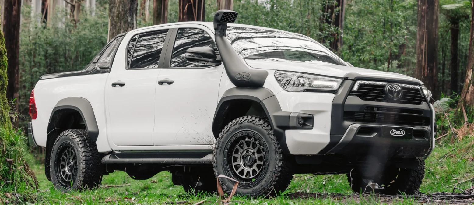 White Toyota truck in a forest setting