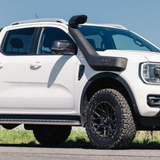White Ford Ranger pickup truck on a road with a clear blue sky